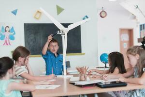 Elementary School Stem Robotics Classroom Diverse Group of Children Building and Programming windmill ecology robot concept. Together Talking and Working as a Team. Creative Robotics Engineering photo