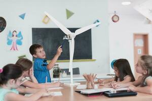 Elementary School Stem Robotics Classroom Diverse Group of Children Building and Programming windmill ecology robot concept. Together Talking and Working as a Team. Creative Robotics Engineering photo