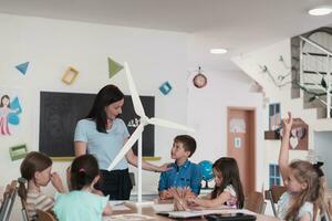 Elementary School Stem Robotics Classroom Diverse Group of Children Building and Programming windmill ecology robot concept. Together Talking and Working as a Team. Creative Robotics Engineering photo