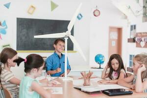 Elementary School Stem Robotics Classroom Diverse Group of Children Building and Programming windmill ecology robot concept. Together Talking and Working as a Team. Creative Robotics Engineering photo