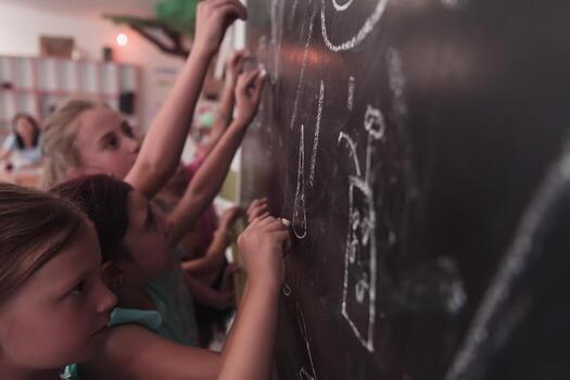Children write and draw on the blackboard in elementary school while learning the basics of education photo