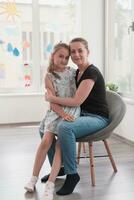 Portrait of a mother and daughter in a modern institution for preschool education photo