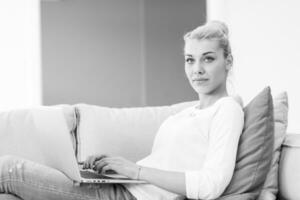 Young woman using laptop at home photo