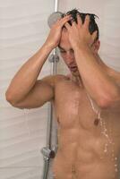 man taking shower in bath photo