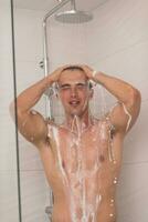 man taking shower in bath photo