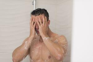 man taking shower in bath photo