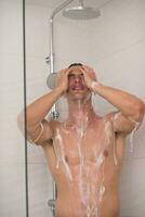 man taking shower in bath photo