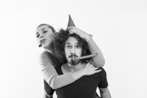 couple in party hats blowing in whistle photo