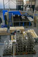 The first phase of metal and aluminum processing. Processed products from CNC machines stacked on a pallet in a large modern factory photo