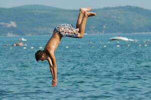 boy jump sea photo