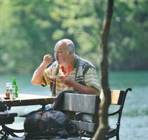 el anciano come postre en el restaurante al aire libre foto