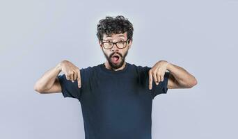 Amazed man pointing down isolated, Shocked person pointing down with fingers isolated, Amazed young man pointing down photo