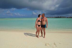 feliz pareja joven divertirse en la playa foto