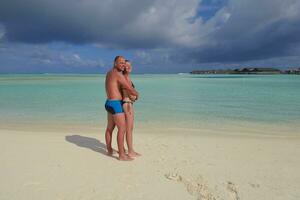 feliz pareja joven divertirse en la playa foto