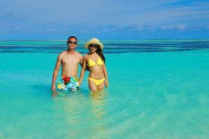 feliz pareja joven disfrutando del verano en la playa foto