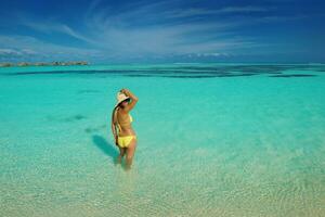 asian woman resting on sand at beach photo