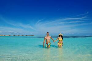 happy young  couple enjoying summer on beach photo