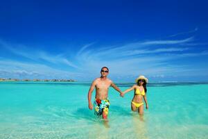 feliz pareja joven disfrutando del verano en la playa foto