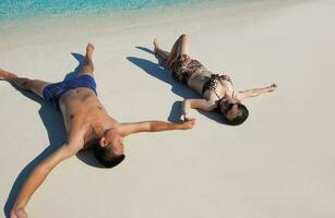 feliz pareja joven disfrutando del verano en la playa foto