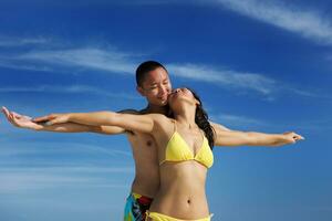 happy young  couple enjoying summer on beach photo