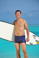 Man with surf board on beach photo