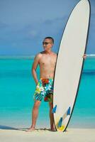 Man with surf board on beach photo