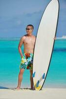 Man with surf board on beach photo