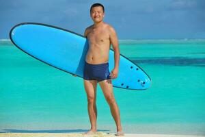 Man with surf board on beach photo