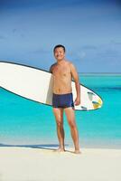 Man with surf board on beach photo