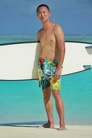 Man with surf board on beach photo