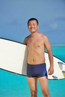 Man with surf board on beach photo