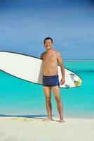 Man with surf board on beach photo