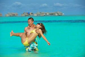 happy young  couple enjoying summer on beach photo