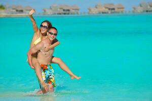 happy young  couple enjoying summer on beach photo