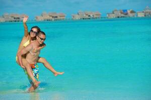 happy young  couple enjoying summer on beach photo