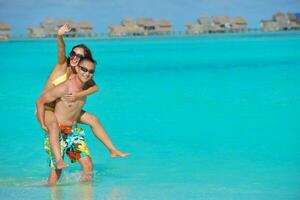 feliz pareja joven disfrutando del verano en la playa foto