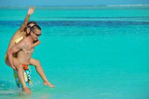 happy young  couple enjoying summer on beach photo