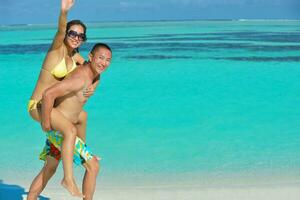 feliz pareja joven disfrutando del verano en la playa foto