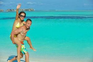 happy young  couple enjoying summer on beach photo