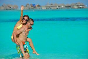 happy young  couple enjoying summer on beach photo