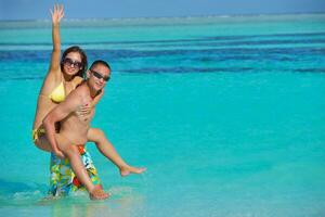 feliz pareja joven disfrutando del verano en la playa foto