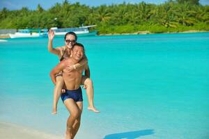 feliz pareja joven disfrutando del verano en la playa foto