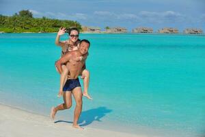 happy young  couple enjoying summer on beach photo