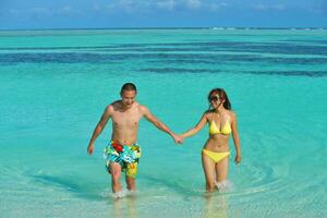 happy young  couple enjoying summer on beach photo