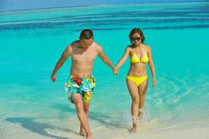 happy young  couple enjoying summer on beach photo