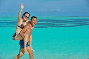 happy young  couple enjoying summer on beach photo