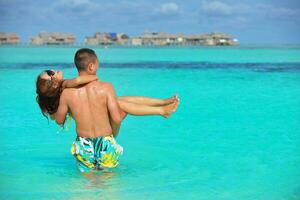 happy young  couple enjoying summer on beach photo