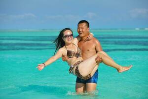 feliz pareja joven disfrutando del verano en la playa foto