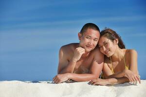 feliz pareja joven disfrutando del verano en la playa foto