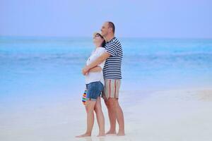 feliz pareja joven divertirse en la playa foto